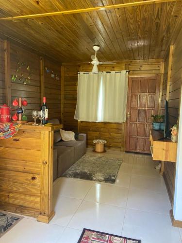 Una sala de estar con un sofá y un techo de madera. en Recanto da Tia Juju, en Santa Teresa