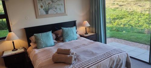 a bedroom with a large bed and a large window at Sunset place, Cathkin Estate in Ardmore
