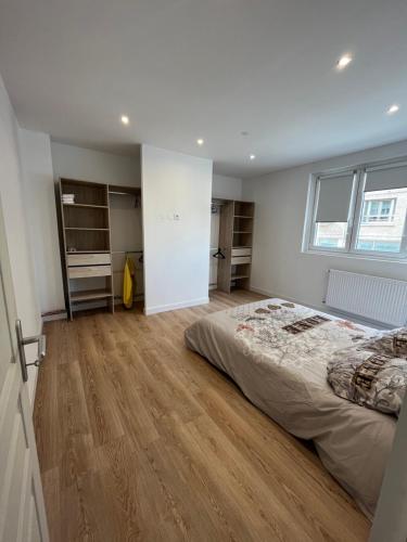 una camera con un grande letto e un pavimento in legno di Loft à deux pas de la plage a Dunkerque