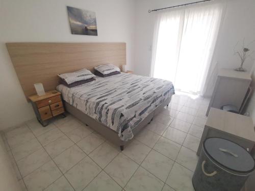 Schlafzimmer mit einem Bett mit einem Kopfteil aus Holz in der Unterkunft 103 Regina Gardens in Paphos City