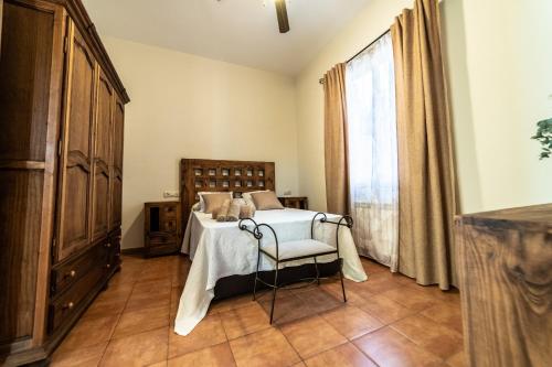 a bedroom with a bed and a chair and a window at Casa El Oasis del Lago Alojamiento Rural in Córdoba