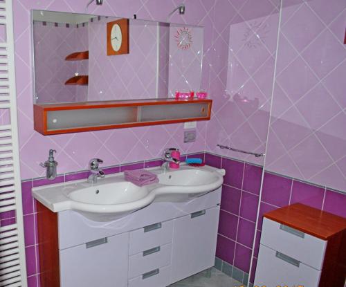 a pink bathroom with a sink and a mirror at Zaffiro Blu in Bellaria-Igea Marina