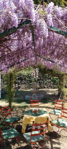 a table and chairs under an arch with purple flowers at Rincón Spa Seule in Ciudad Lujan de Cuyo