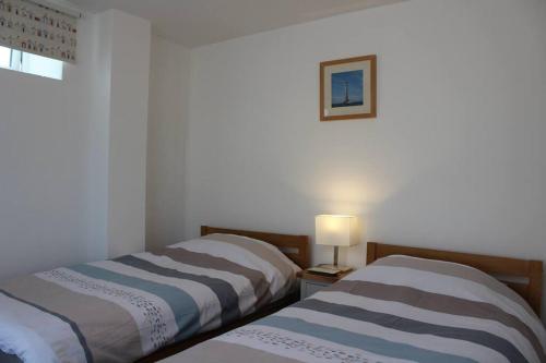 two beds sitting next to each other in a room at The Nest in Little Haven