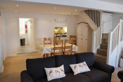 a living room with a couch and a dining room at The Nest in Little Haven