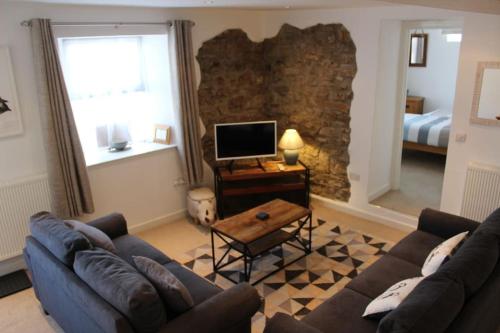 a living room with a couch and a television at The Nest in Little Haven