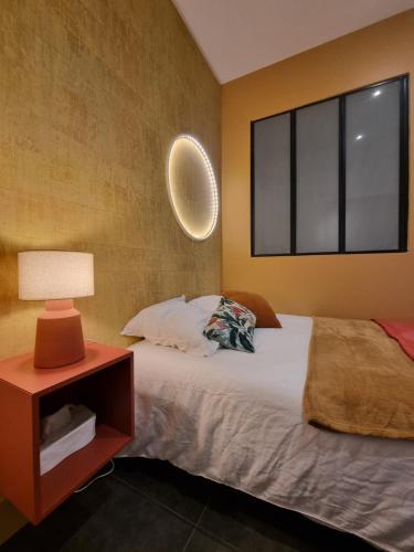 1 dormitorio con 1 cama con lámpara y ventana en Villa St-Gau en Saint-Gaudens