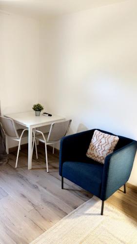 un salon avec une chaise bleue et une table dans l'établissement Chambre provençale, à Arles