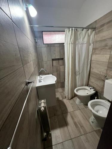 a bathroom with a toilet and a sink and a shower at Chalet Mariam in Villa Carlos Paz