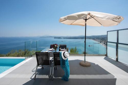 a table with an umbrella on a balcony with a view at Cp 5 Bedrooms NL Villas Lucas Clara Pyrgi in Pyrgi