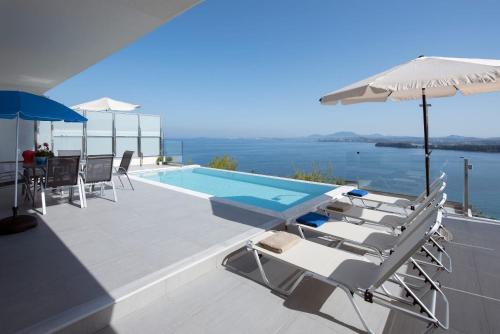 a swimming pool with lounge chairs and an umbrella at Cp 5 Bedrooms NL Villas Lucas Clara Pyrgi in Pyrgi