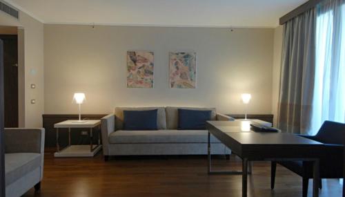 a living room with a couch and a table at Ramada Plaza by Wyndham Milano in Milan