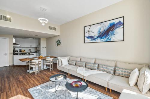 a living room with a couch and a table at Luxury 1 Bedroom Apartment in Discovery Gardens in Dubai