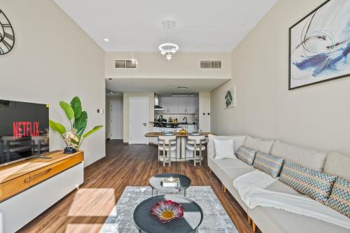 a living room with a couch and a table at Luxury 1 Bedroom Apartment in Discovery Gardens in Dubai