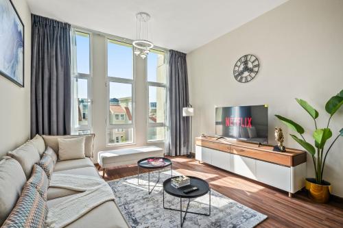 a living room with a couch and a tv at Luxury 1 Bedroom Apartment in Discovery Gardens in Dubai