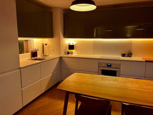 uma cozinha com uma mesa de madeira no meio em Family appartement near 2024 Arena & Olympics em Issy-les-Moulineaux
