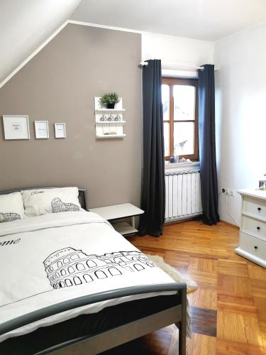 a bedroom with a bed and a window at Apartmaji ARKO in Ribnica
