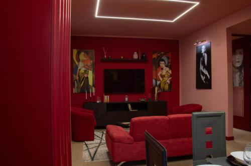 a red living room with a red couch and a tv at la casa dell'arte in Pistoia