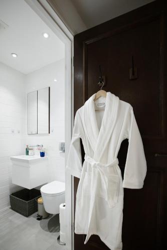 a white robe hanging on a door in a bathroom at Prime West End The Covent Garden Design Flat in London