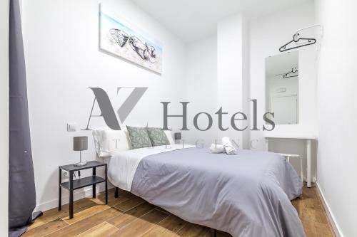 un dormitorio blanco con una gran señal de hotel en la pared en A&Z Luis Cabrera-Auto check-in property, en Madrid