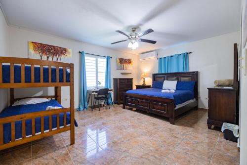 - une chambre avec 2 lits superposés et un ventilateur de plafond dans l'établissement Big Vacation House, à Moca