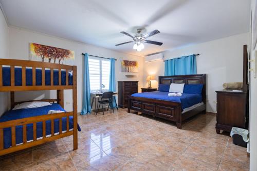 a bedroom with two bunk beds and a ceiling fan at Big Vacation House in Moca