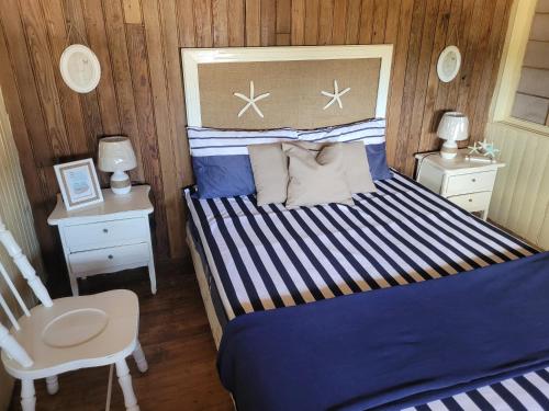 a bedroom with a bed and two night stands and a chair at La Cabaña de Vito in La Paloma
