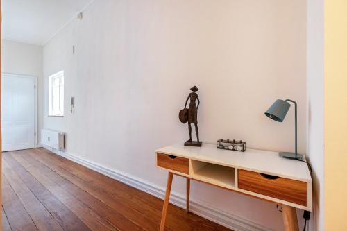 a white room with a desk with a lamp on it at Wohnoase im Denkmal in Garding