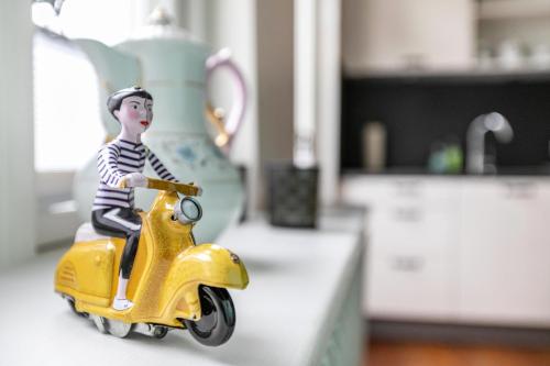 a toy man riding a yellow scooter on a counter at Wohnoase im Denkmal in Garding