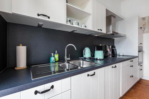a kitchen with white cabinets and a sink at Wohnoase im Denkmal in Garding