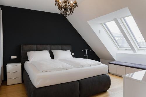 een slaapkamer met een groot bed met een zwarte muur bij Modern stylish design apartment with free parking Emily in Wenen