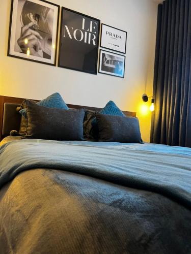 a bedroom with a bed with blue sheets and pictures on the wall at Trendy Seaside Escape 2 Bedroom Penthouse in Marsaskala