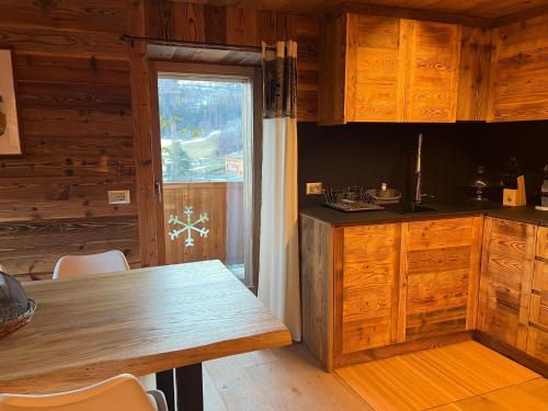 a kitchen with wooden cabinets and a wooden table at CASA VITTORIA in Gignod