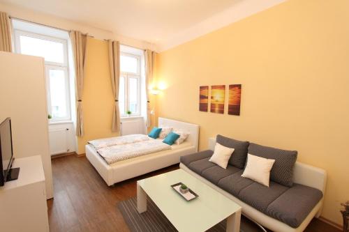 ein Wohnzimmer mit einem Sofa und einem Tisch in der Unterkunft Hotel Klimt in Wien