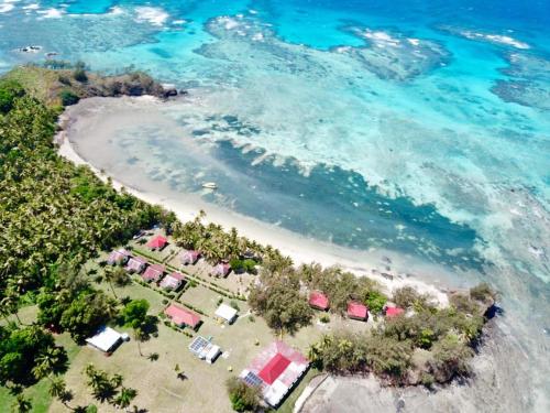 una vista aérea de una playa con un grupo de tiendas de campaña en S@fe Landing Lodge, en Nacula Island