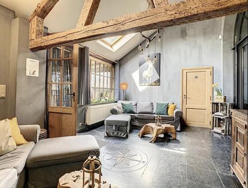 a living room with two couches and a table at The Lodge Ardenne in Tailles