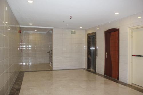 un couloir avec une porte et un mur en carrelage dans l'établissement جوان سويت للشقق المخدومة, à Djeddah