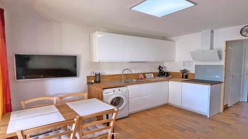 une cuisine avec un évier et une machine à laver dans l'établissement Boucanniers, à Sainte-Maxime
