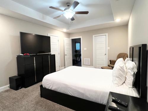 1 dormitorio con cama blanca y ventilador de techo en Spotless, en Clarksville