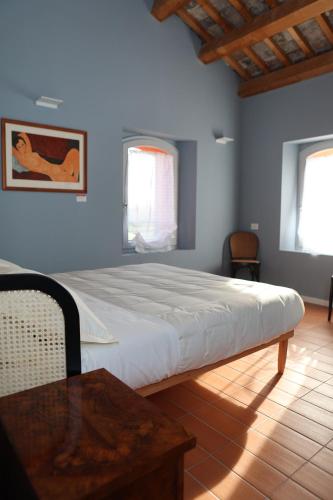 una camera con un grande letto e un tavolo in legno di Locanda Lingua a Rimini