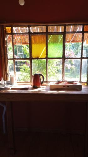 BIVAQUE hospedaje في تيغري: نافذة فيها غلاية شاي تجلس امامها