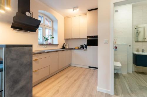 a kitchen with white cabinets and a sink at Apartament Smile - z prywatnym monitorowanym parkingiem by SpaceApart in Jelenia Góra