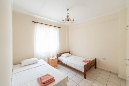 una camera con due letti e una finestra di Vintage Family Comfort By Greece Apartment a Aigio