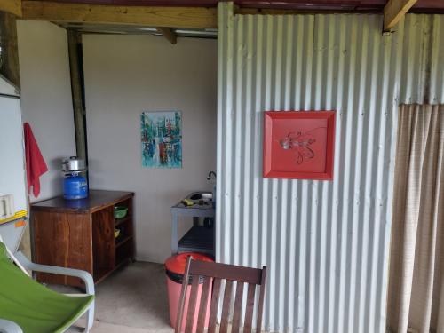 Cette chambre dispose d'un bureau et d'une photo rouge sur le mur. dans l'établissement Map of Africa Luxury Caravan with private bathroom with sea view, à Wilderness