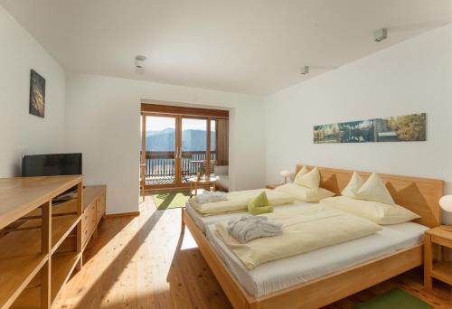 a bedroom with a large bed and a desk at Hotel Ramsauhof Pool & Wellness Breakfast & Light Dinner Buffet in Ramsau am Dachstein