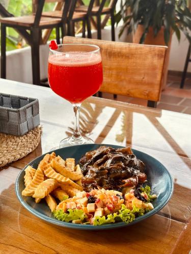 a plate of food on a table with a drink at Hotel Campestre Palmas del Zamorano in San Gil