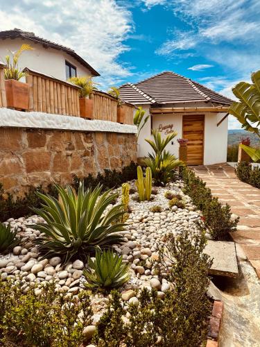 a garden with plants and a house at Hotel Campestre Palmas del Zamorano in San Gil