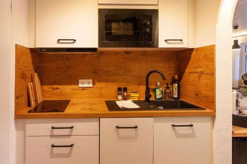 eine Küche mit Spüle und Mikrowelle in der Unterkunft Stube Elli mit Oberstaufen Plus Karte in Oberstaufen