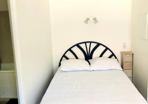 ein Schlafzimmer mit einem Bett mit zwei Kissen darauf in der Unterkunft Studio à 20 min de Walibi in Le Pont-de-Beauvoisin