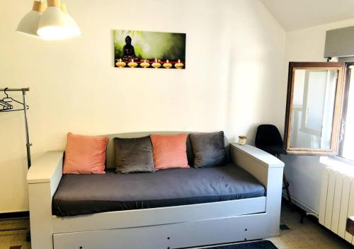 ein Sofa mit bunten Kissen darauf im Zimmer in der Unterkunft Studio à 20 min de Walibi in Le Pont-de-Beauvoisin